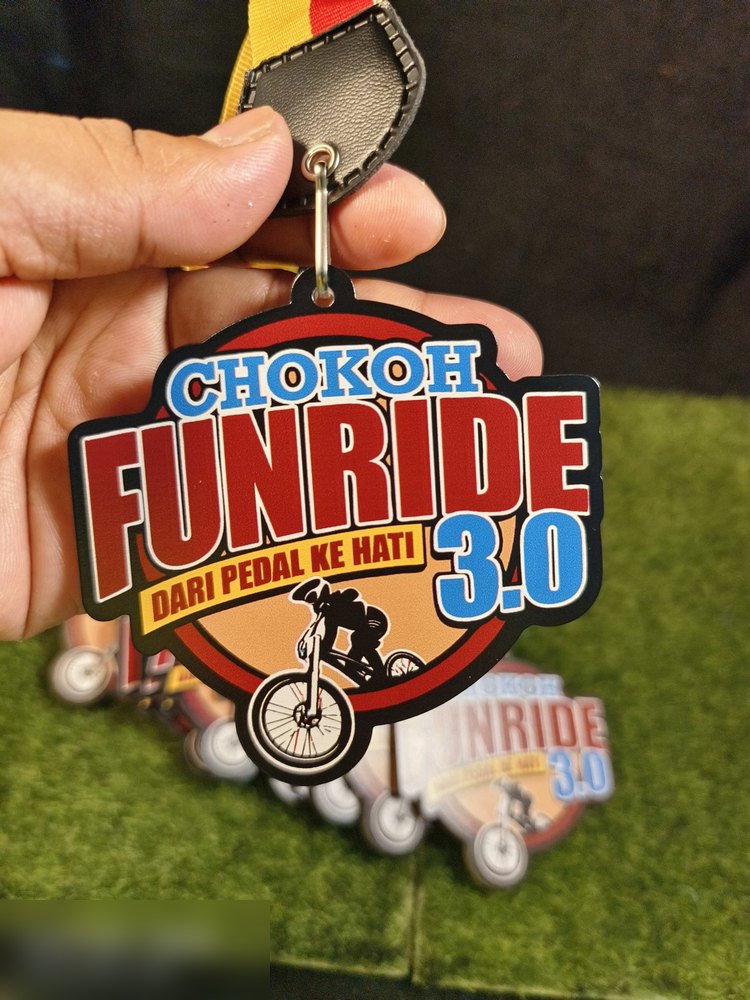 Medal Chokoh Funride 3.0 'Dari Pedal Ke Hati' — acara berbasikal. Bentuk custom bulat dengan bingkai hitam tebal, warna merah, biru dan krim, serta silhouette pelumba basikal. Digantung dengan tab kul