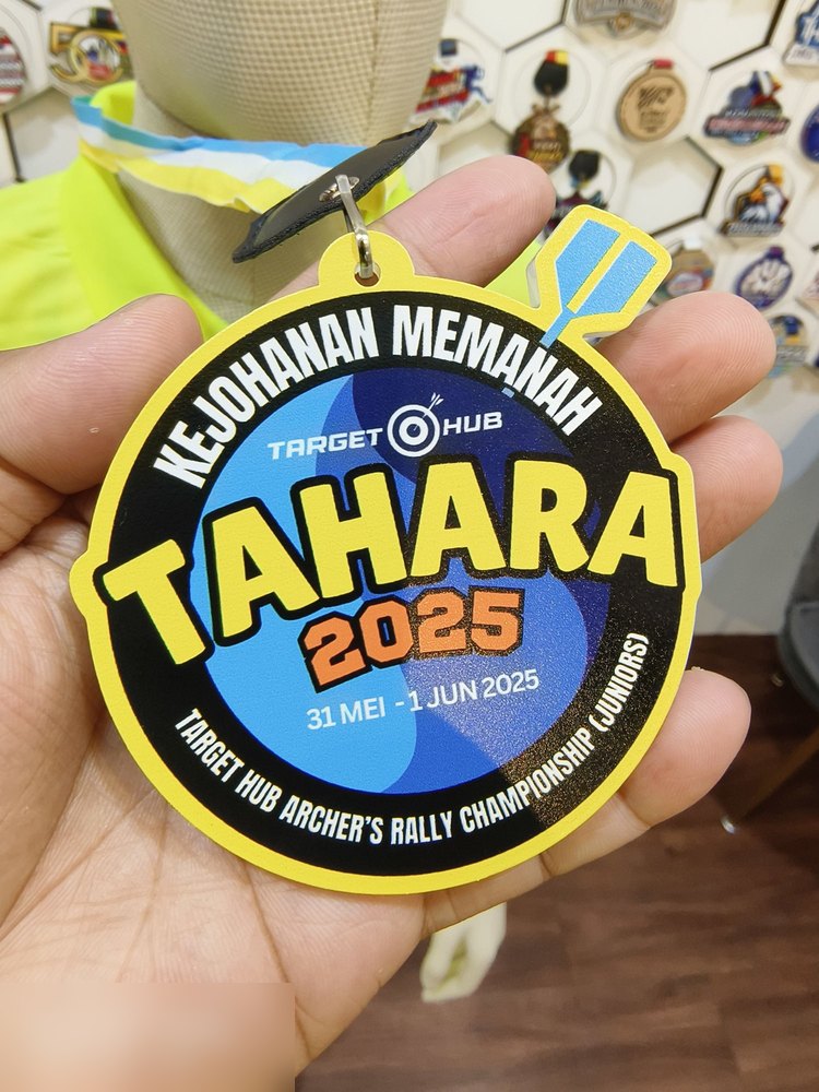 Medal Kejohanan Memanah TAHARA 2025, Target Hub Archer's Rally Championship (Juniors), 31 Mei - 1 Jun 2025. Bentuk bulat bingkai KUNING terang, latar hitam dgn sasaran biru. Gantungan berbentuk ANAK P