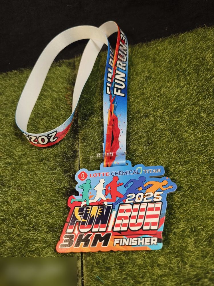 Medal Fun Run 3KM Finisher 2025 anjuran Lotte Chemical Titan — larian korporat. Bentuk custom mengikut teks 'FUN RUN'. Warna terang biru, merah, oren dengan lima silhouette pelari pelbagai warna. Teks
