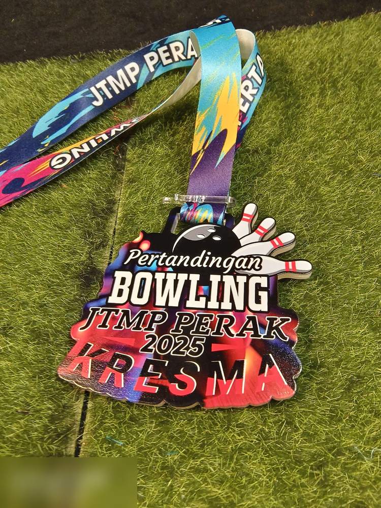 Medal Pertandingan Bowling JTMP Perak 2025 (Kresma). Bentuk custom dengan pin bowling dan bola timbul di bahagian atas. Warna gelap dengan letupan merah, biru dan ungu. Lanyard bercetak penuh corak wa