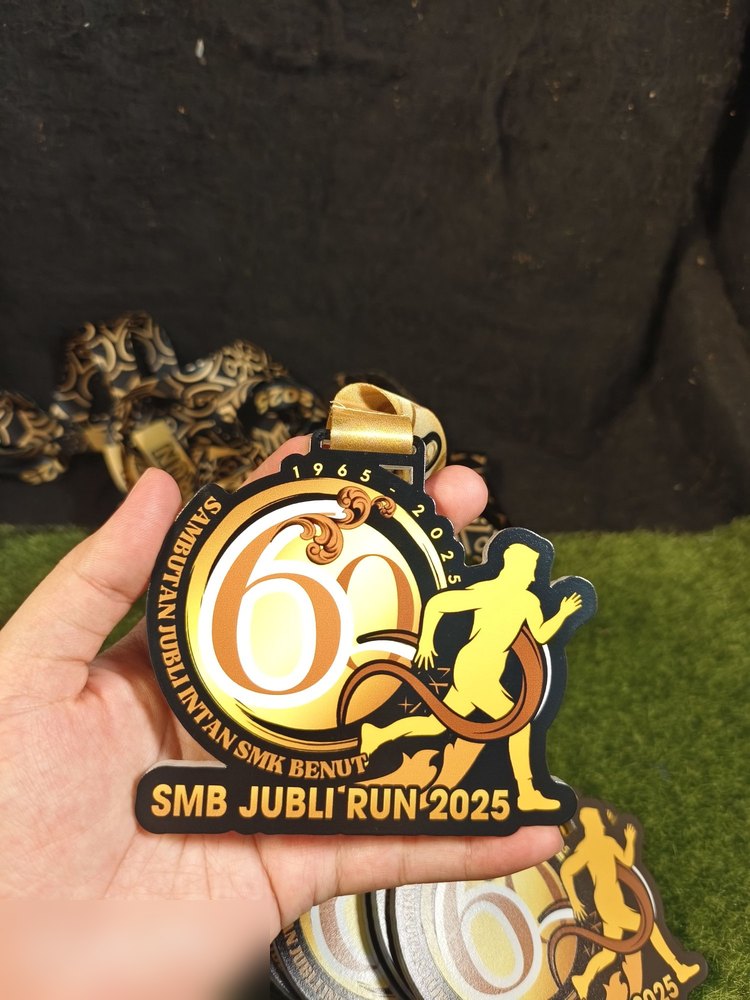 Medal SMB Jubli Run 2025 sempena Sambutan Jubli Intan SMK Benut (1965-2025, 60 tahun). Bentuk custom dengan angka '60' besar berkilat emas dan pelari emas di sebelah kanan. Latar hitam. Reben emas. Co