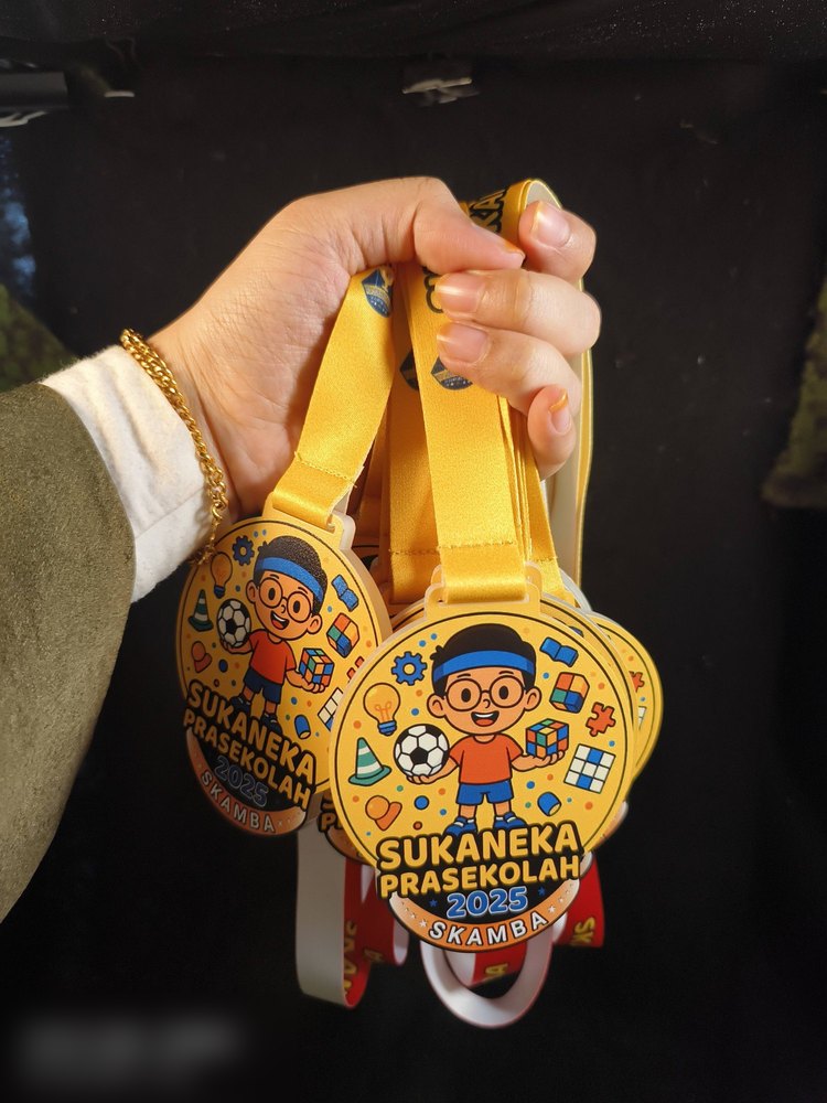 Medal Sukaneka Prasekolah SKAMBA 2025 dipegang beberapa keping sekali gus, dengan lanyard kuning. Tunjuk rupa sebenar bila order untuk satu kelas / satu sekolah.